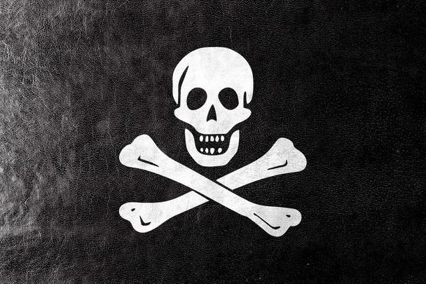 The traditional Jolly Roger of piracy Flag, painted on leather texture - Photo, Image