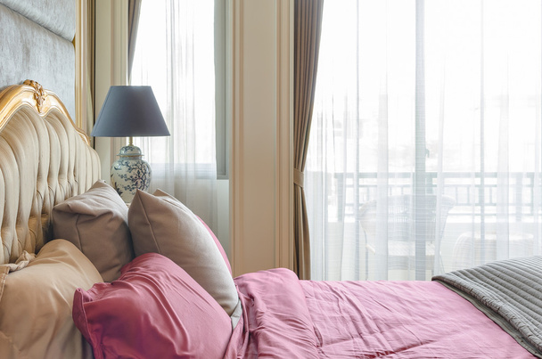 ylellinen makuuhuone klassinen sänky tyyli ja punainen tyyny
  - Valokuva, kuva