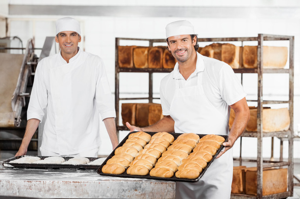 Baker Showing Breads In Baking Tray By Colleague - Fotografie, Obrázek