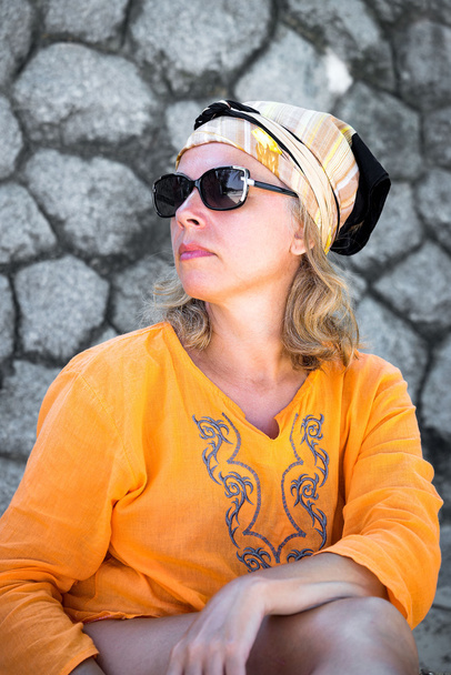 Schöne Frau mit Sonnenbrille in der Nähe der Steinmauer - Foto, Bild