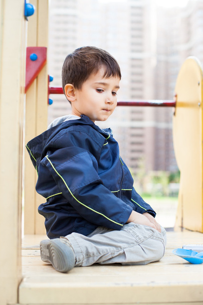 Boy sits on playground - Fotoğraf, Görsel