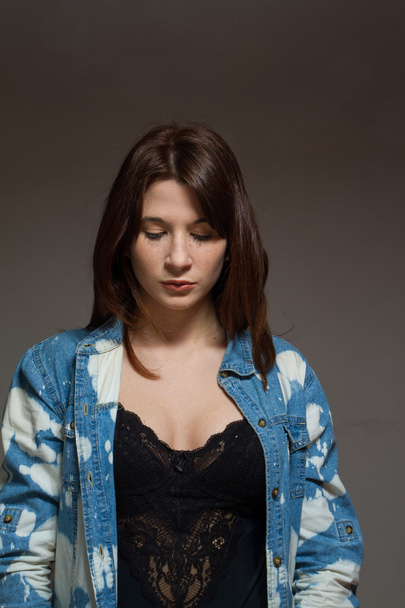 Freckled woman wearing a jean shirt looking down - Fotografie, Obrázek