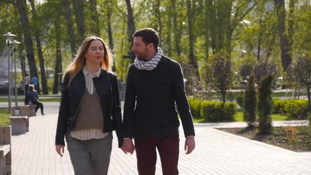Loving couple walking along park alley - Filmati, video