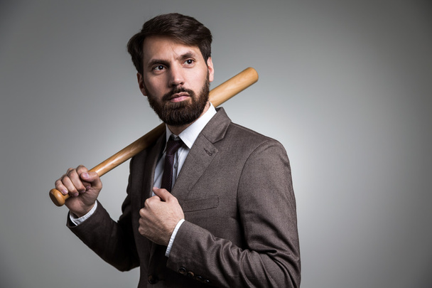 Businessman with bat on shoulder - Фото, изображение