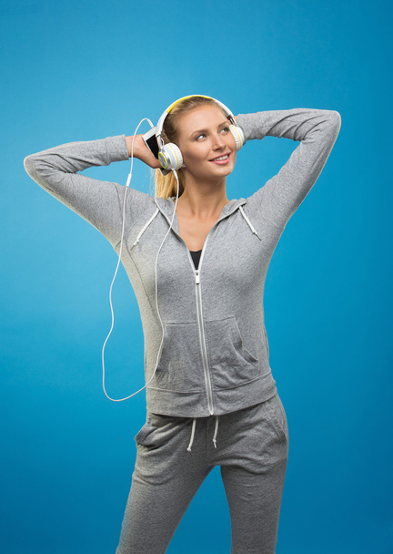 Attractive young sportswoman listening to music - Foto, Imagen