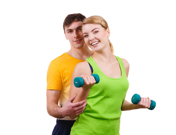 Couple exercising with dumbbells lifting weights  - Valokuva, kuva