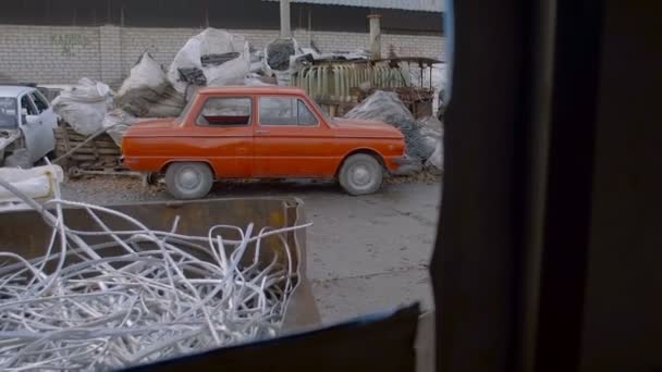Stary samochód w rupieciarni czeka do recyklingu metali - Materiał filmowy, wideo