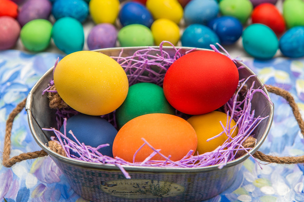 Colorful Easter eggs on bright background. Easter holiday. Multicolored background green, blue and purple colors. Easter eggs in a basket. - Photo, Image