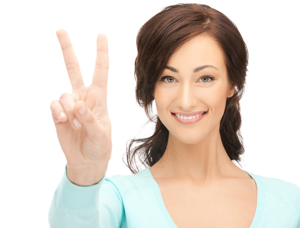 Young woman showing victory sign - Foto, afbeelding
