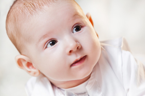newborn baby in a beautiful white dress on a light background , portrait . - Zdjęcie, obraz