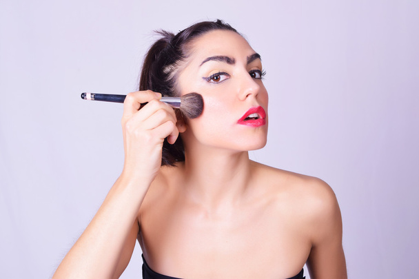 Closeup of young hispanic woman applying makeup - Photo, Image