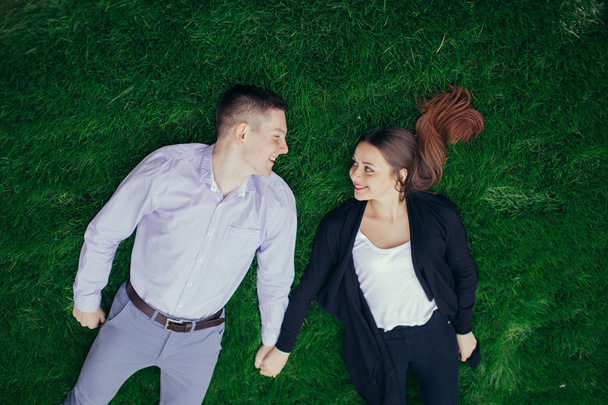 Lovely couple liying on the grass and smile - Photo, image
