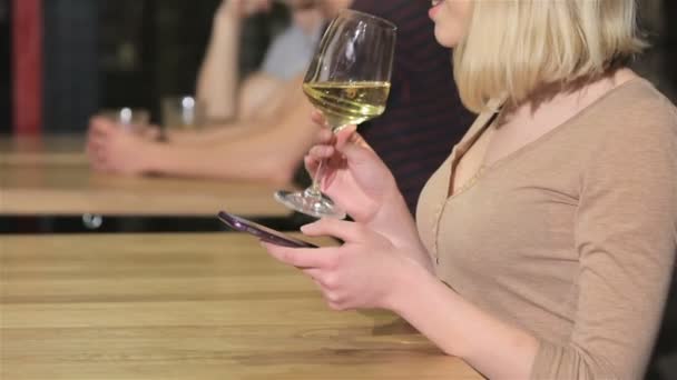 Close up of a young woman drinks wine holding phone in her hand - Video, Çekim
