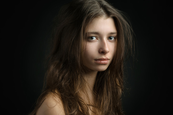 Dramatic portrait of a girl theme: portrait of a beautiful girl on a background in the studio - Valokuva, kuva