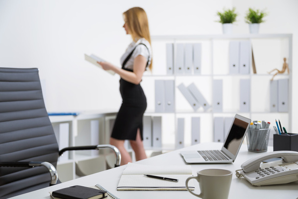 Office desk and standing businesswoman - Zdjęcie, obraz
