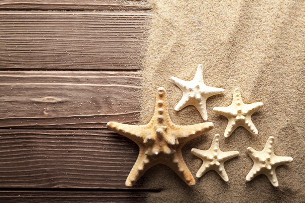 Starfishes on sand and wooden table - Foto, Imagen