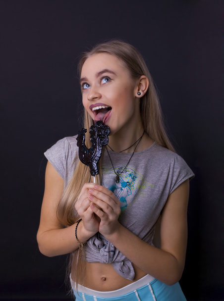 portrait of a girl with a lollipop on a black background - Foto, Bild