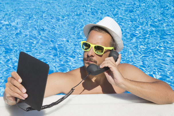 Guy having an internet call from the swimming pool      - Foto, Bild