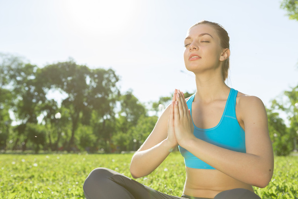 Woman meditating in park - Photo, Image