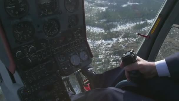 View control system pilot hold lever of helicopter. Camera in pilot cabin. Above forest. Sunny. Snow - Footage, Video