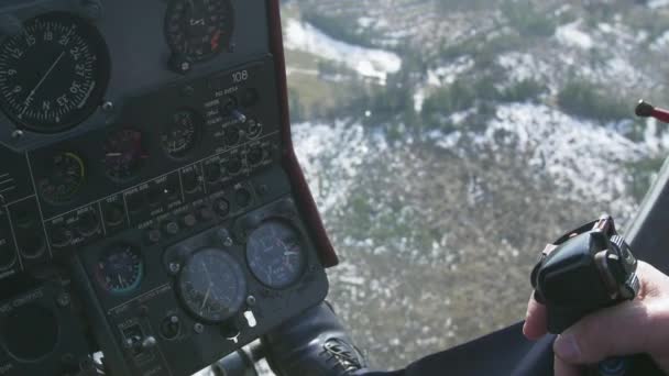 View control system pilot hold lever of helicopter. Camera in pilot cabin. Above forest. Some snow - Footage, Video
