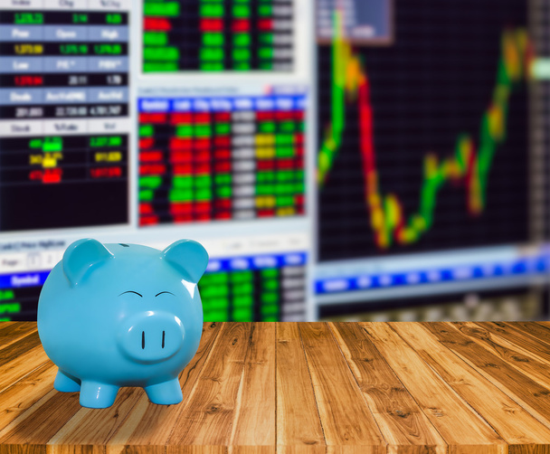 синій свинячий банк на дерев'яному фоні з розмитим фондовим ринком backgrou
 - Фото, зображення