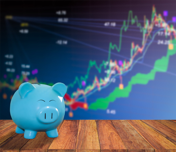 blue pig bank on wood background with blur stock market backgrou - Photo, Image