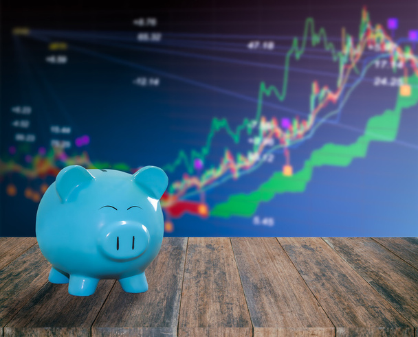 синій свинячий банк на дерев'яному фоні з розмитим фондовим ринком backgrou
 - Фото, зображення