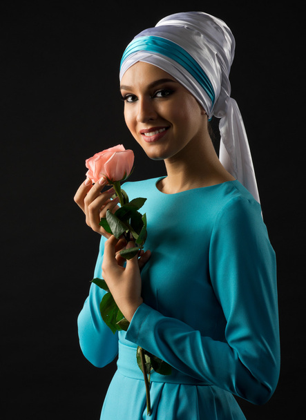 Muslim woman in blue dress with rose flower - Фото, изображение