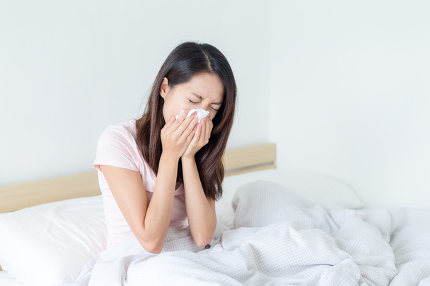 Sick woman sneezing into tissue   - Fotografie, Obrázek