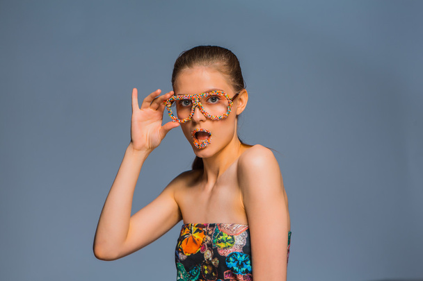 Girl with candy sprinkles on lips ang glasses - Zdjęcie, obraz