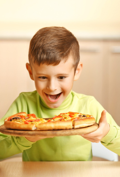 Little boy eating pizza   - Foto, afbeelding