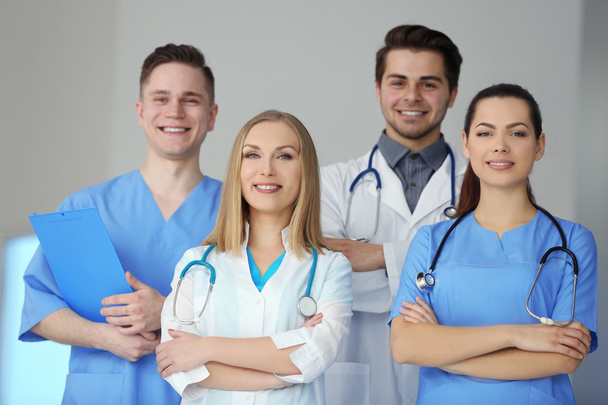 A group of doctors and nurses standing in the hospital, indoors - Фото, изображение