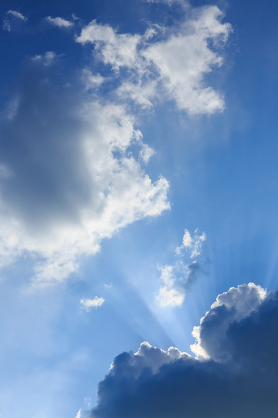 sunbeam of sunlight through clouds on clear blue sky - Photo, Image
