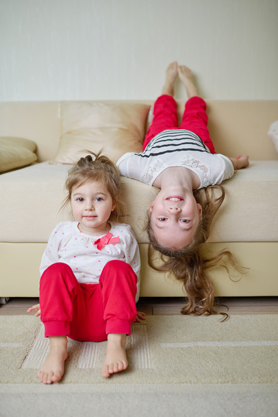 cute girls on the couch upside down - Zdjęcie, obraz