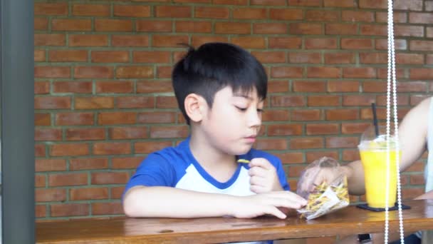 Happy asian mom with her son eating snack and playing together make fun - Footage, Video