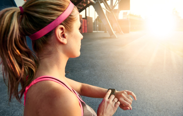 Woman programming her smartwatch before going jogging to track performance - Foto, Imagem