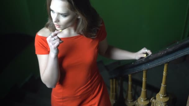 szép nő visel piros ruha, a lépcsőn - Felvétel, videó