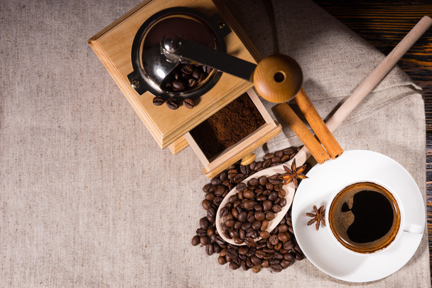 Grinder with coffee beans and wooden spoon - Fotó, kép