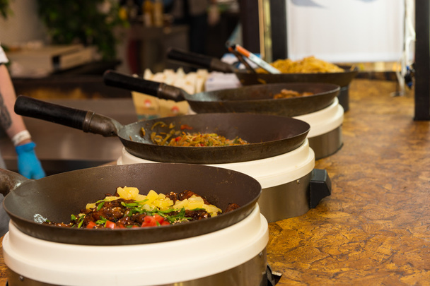 Řada pánví s vařenými potravinami opřené o stůl - Fotografie, Obrázek