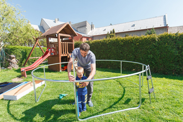 Father and son when installing large garden trampolines. - Foto, Imagem