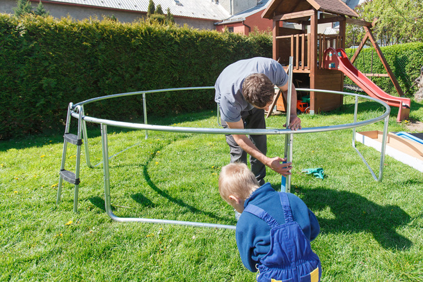 Father and son when installing large garden trampolines. - Fotó, kép