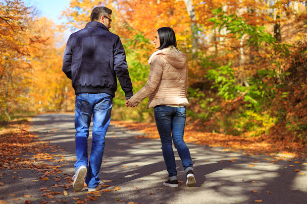 Jeune couple tenant la main tout en faisant une promenade
  - Photo, image