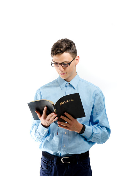 Teenager read and study from big book bible with eyeglasses isol - Foto, imagen