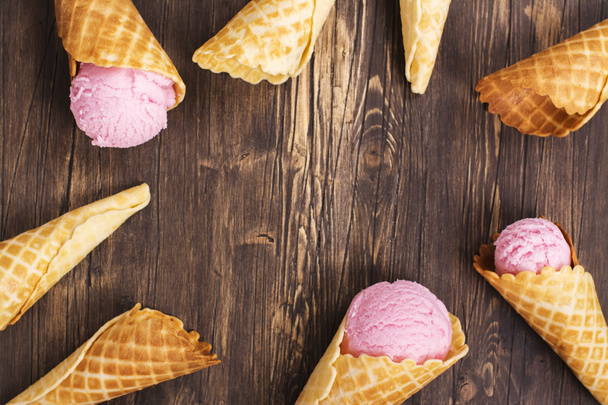 Ice cream in waffle cones over wooden background - Foto, imagen