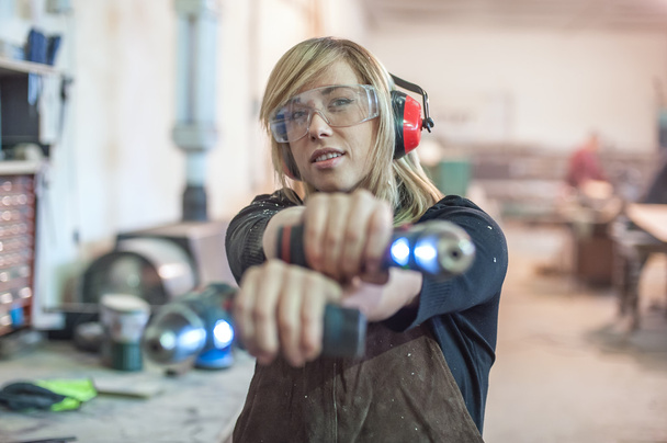 Female carpenter using power drill - Fotoğraf, Görsel