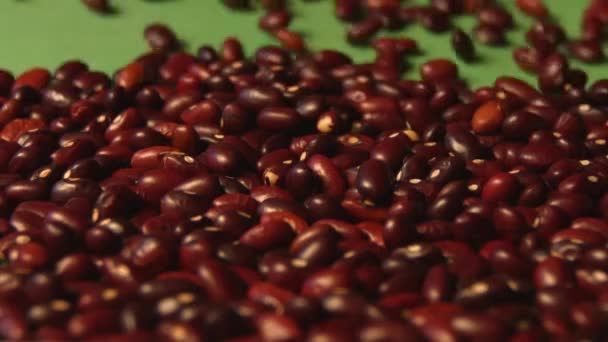Brown beans on a green background. Slow motion. Close-up. Horizontal pan. 3 Shots - Záběry, video