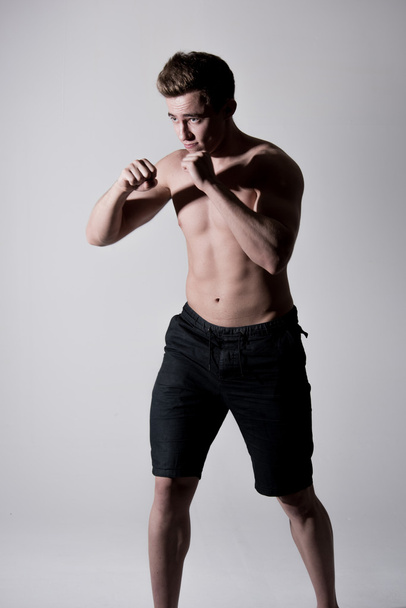 Powerful young fighter man in fighting stance - Φωτογραφία, εικόνα