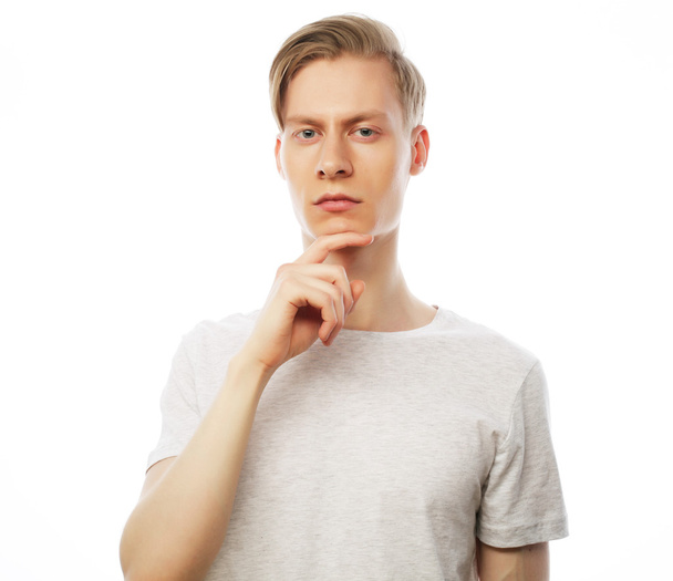 Portrait of the young thinking man with hand near face - Photo, image