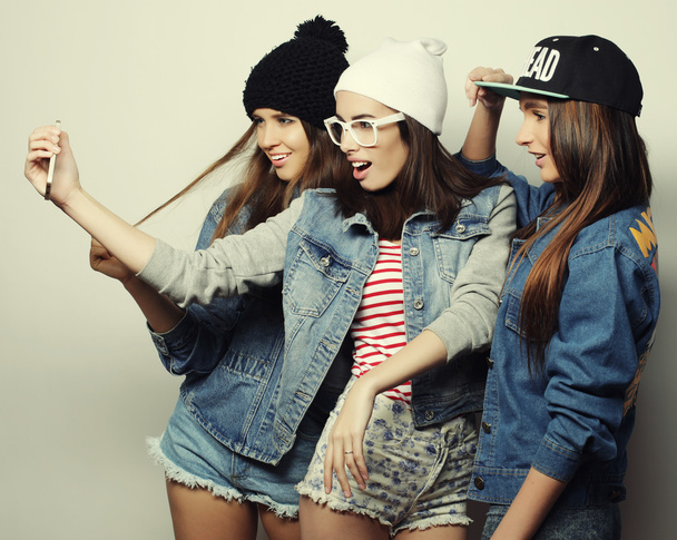 three happy teenage girls with smartphone taking selfie - Фото, зображення